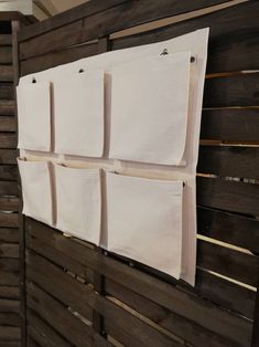 several pieces of white cloth hanging on a wooden wall