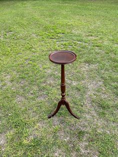 a small wooden table sitting on top of a lush green field