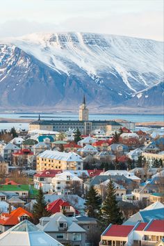 a city with mountains in the background and snow on the top of it's peaks