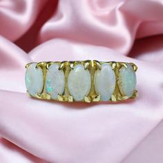 FREE SAME DAY SHIPPING & GIFT WRAPPING! A beautiful Antique victorian Five Stone Prong Opal Ring! This alluring 14kt gold antique ring holds 5 approximate 5x3.5mm opals along a stylish prong setting. The whites opal are simply mesmerizing, displaying an array of iridescent colors that flash and shimmer! A variety of colorful shades are included in the color play, almost seeming to glow from within. Completing the design are the sleek shoulders, which extend to a smooth gold band in the back. A s Gold Antique Ring, Emerald Pendants, Fashion Diamond Rings, 14k Gold Opal Ring, Rings Birthstone, Gold Opal Ring, Jewelry Ruby, Natural Opal Ring, Rings Sapphire