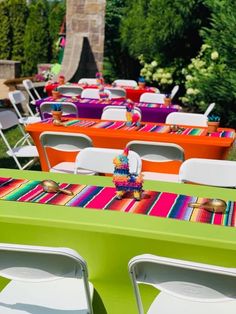 colorful tables and chairs are set up for an outdoor party