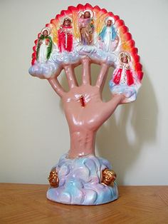 a ceramic figurine depicting the palm of jesus with seven children on it's hands