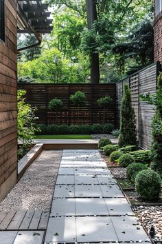 Modern backyard with stone pathway, bordered by lush shrubs and small trees. Wooden fencing provides privacy, surrounded by green foliage. Privacy Screen Ideas, Small Patio Design, Outdoor Covered Patio, Privacy Fence Designs, Patio Projects, Back Garden Design