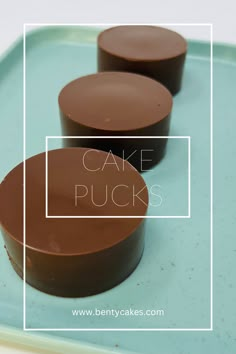 three cakes sitting on top of a blue tray with the words cake pucks over it