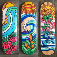 three skateboards with different designs on them