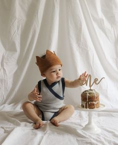 a baby sitting in front of a cake