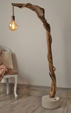 a lamp that is on top of a wooden floor next to a chair and pillow