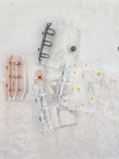 three clear plastic containers sitting on top of a white rug next to metal clips and screws