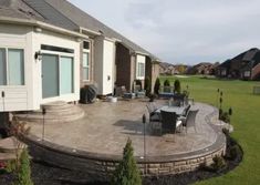 an outdoor patio with chairs and table in the middle