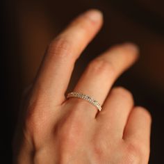 a woman's hand with a diamond ring on her left hand, showing the band