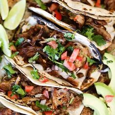 three tacos with meat, tomatoes and avocado