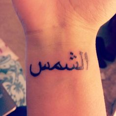 a woman's wrist tattoo with arabic writing on it