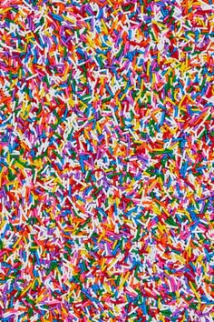 colorful sprinkles are scattered all over the surface