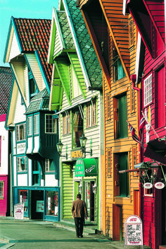 a man walking down the street in front of colorful houses