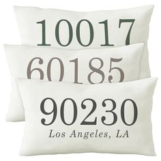 three pillows with numbers on them sitting next to each other in front of a white background