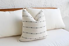 a white pillow sitting on top of a couch