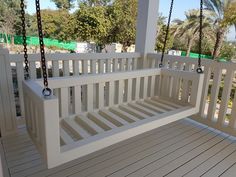 a white porch swing with chains hanging from it