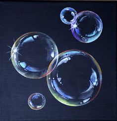 three soap bubbles floating in the air on a black background