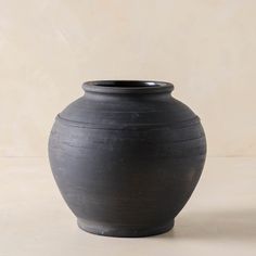 a black vase sitting on top of a table