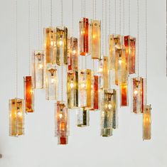 a chandelier made out of glass blocks with lights hanging from the bottom and sides