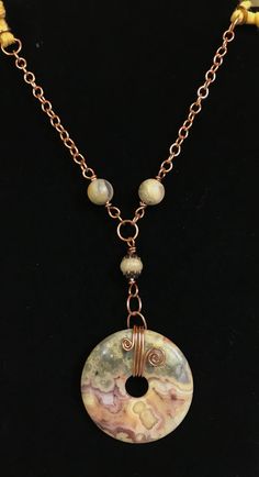 Crazy Lace Agate and Copper Necklace with soft jersey cord. 38" long Main Focal is 2" long Coated with Protectaclear ProtectaClear is a clear, protective coating that is tough enough to protect jewelry and is safe for wear against skin. ProtectaClear is practically invisible once applied and will seal and protect jewelry from tarnish, oxidation, and corrosion Donut Jewelry Pendants, Adjustable Long Agate Crystal Necklace, Adjustable Wire Wrapped Agate Necklace, Leather Bracelet Tutorial, Donut Jewelry, Beaded Ideas, Wire Wrapped Stone Jewelry, Donut Pendant, Ceramic Necklace