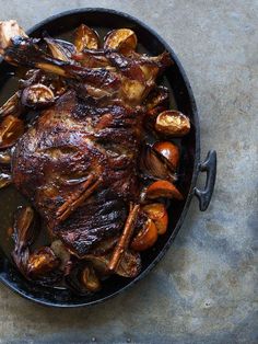 a roasting pan filled with meat and vegetables on top of a stone countertop