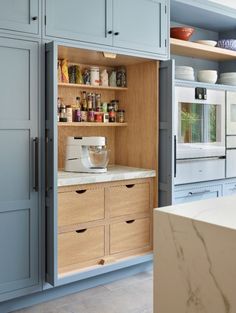 an open cabinet in a kitchen with lots of cupboard space and drawers on the side