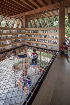 two children playing in a hammock with bookshelves