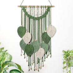 a green and white wall hanging with leaves