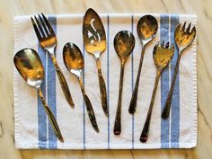 five different types of spoons and forks on a napkin with the number three painted on them