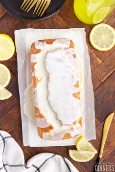 a loaf of lemon pound cake with icing and sliced lemons on the side