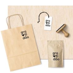 a paper bag, rubber stamp and some other items on a wooden surface with the words grati dao