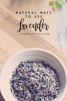 a white bowl filled with lavender on top of a wooden table