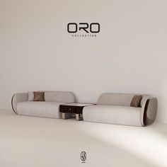 two white couches sitting next to each other in a room with the word oro on it