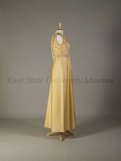 Pierre Balmain Haute Couture evening dress from French 1960-1970. Made from yellow silk satin peau de soie ground, yellow dome caps, embroidered  embroidery with bead, pearl, rhinestones, cream cord loops, white plastic lilies flower, light yellow braid trim,  and dome lucite button. Sleeveless floor length A line gown in scoop necked style.#Balmain #HauteCouture #Vintage #Fashion House of Balmain. A Line Gown, Fashion House, French Fashion