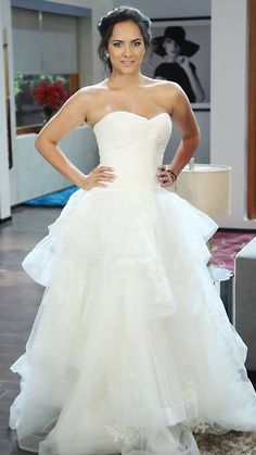 a woman in a wedding dress posing for the camera