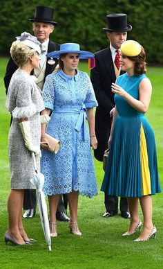 three women in dresses and hats talking to each other on the grass at an outdoor event