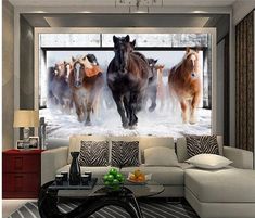 a living room filled with furniture and a painting of horses running in the snow on the wall