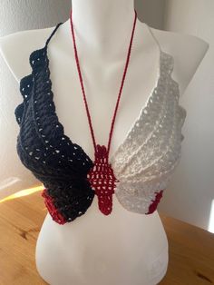 a white mannequin wearing a black, red and white crochet bra