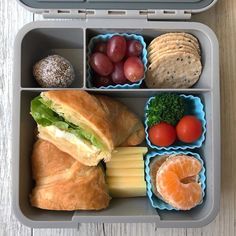 an open lunch box filled with food on top of a wooden table