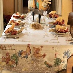 the table is set with place settings for two people to eat and have chicken heads on them