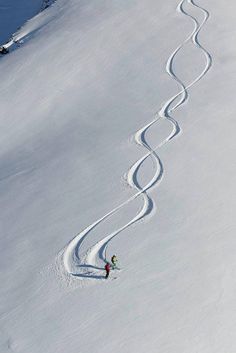 a person skiing down a snow covered slope with lines drawn in the snow behind them