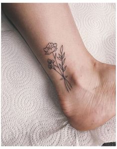 a small flower tattoo on the foot of a woman's right leg, with one single flower in it