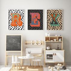 three colorful paintings hang on the wall above a small table and chairs in a white room