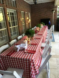 an outdoor dining area with red and white checkered tablecloths