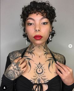 a woman with tattoos on her chest and shoulder