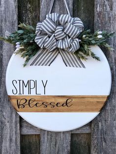 a wooden sign with a bow hanging from it's side that says simply blessed