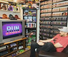 a man sitting in front of a tv with the word run on it