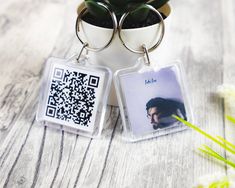 a couple of key chains sitting on top of a table next to a potted plant