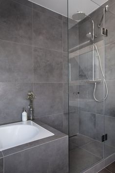 a bathroom with a glass shower door next to a white sink and bathtub in it